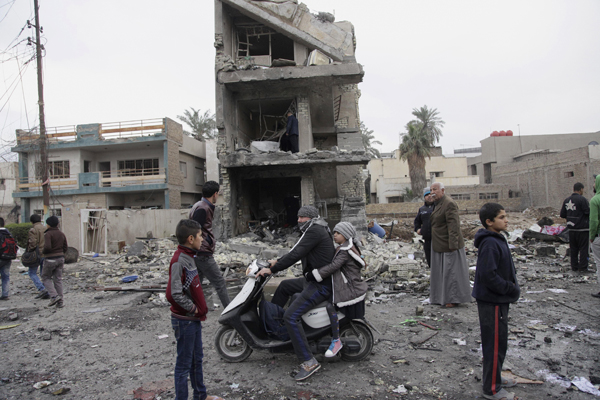 People gather at the scene of a car bomb explosion in commercial area of New Baghdad, on Tuesday (AP photo)